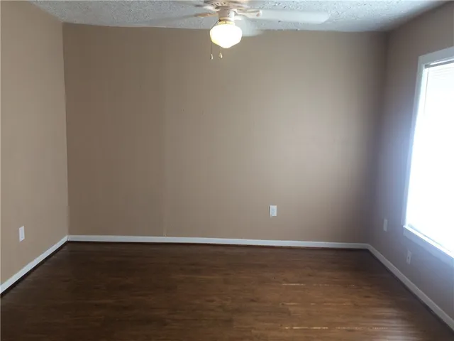 a view of a room with wooden floor and fan