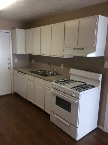 a white stove top oven sitting inside of a kitchen