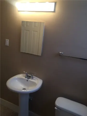 a bathroom with a sink a toilet and mirror