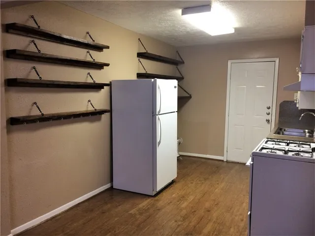 a view of room with wooden floor and cabinets