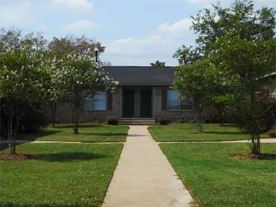 a front view of a house with a yard and trees