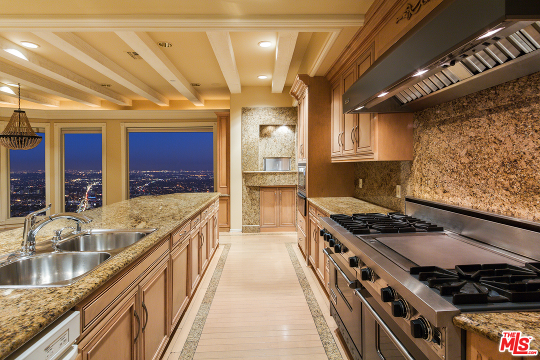 8570 Cole Crest Drive Los Angeles, CA 90046 - Photo 11 of 28 a kitchen with stainless steel appliances granite countertop a stove and a sink