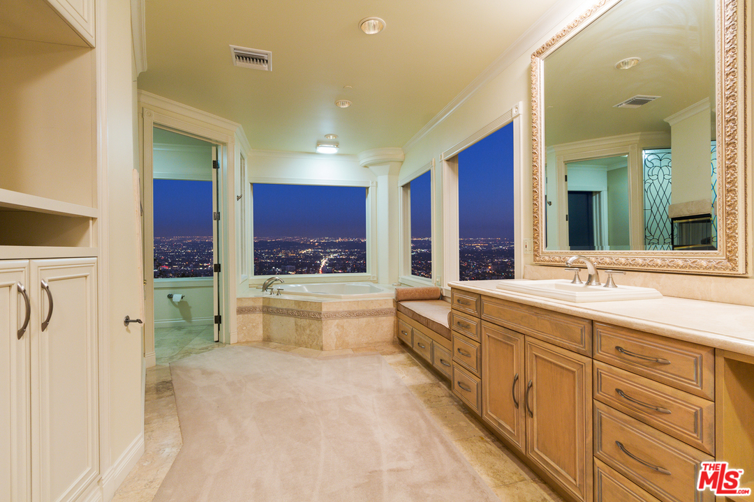 8570 Cole Crest Drive Los Angeles, CA 90046 - Photo 14 of 28 a large bathroom with a granite countertop double vanity sink a mirror and a bathtub