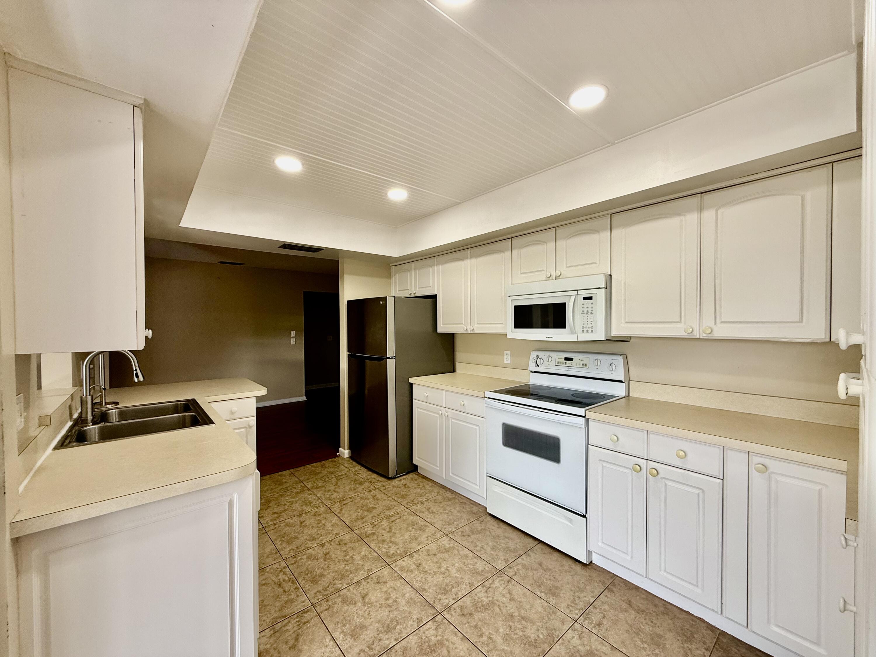 612 Coconut Avenue North Port St. Lucie, FL 34952 - Photo 22 of 32 a kitchen with a sink a stove and refrigerator