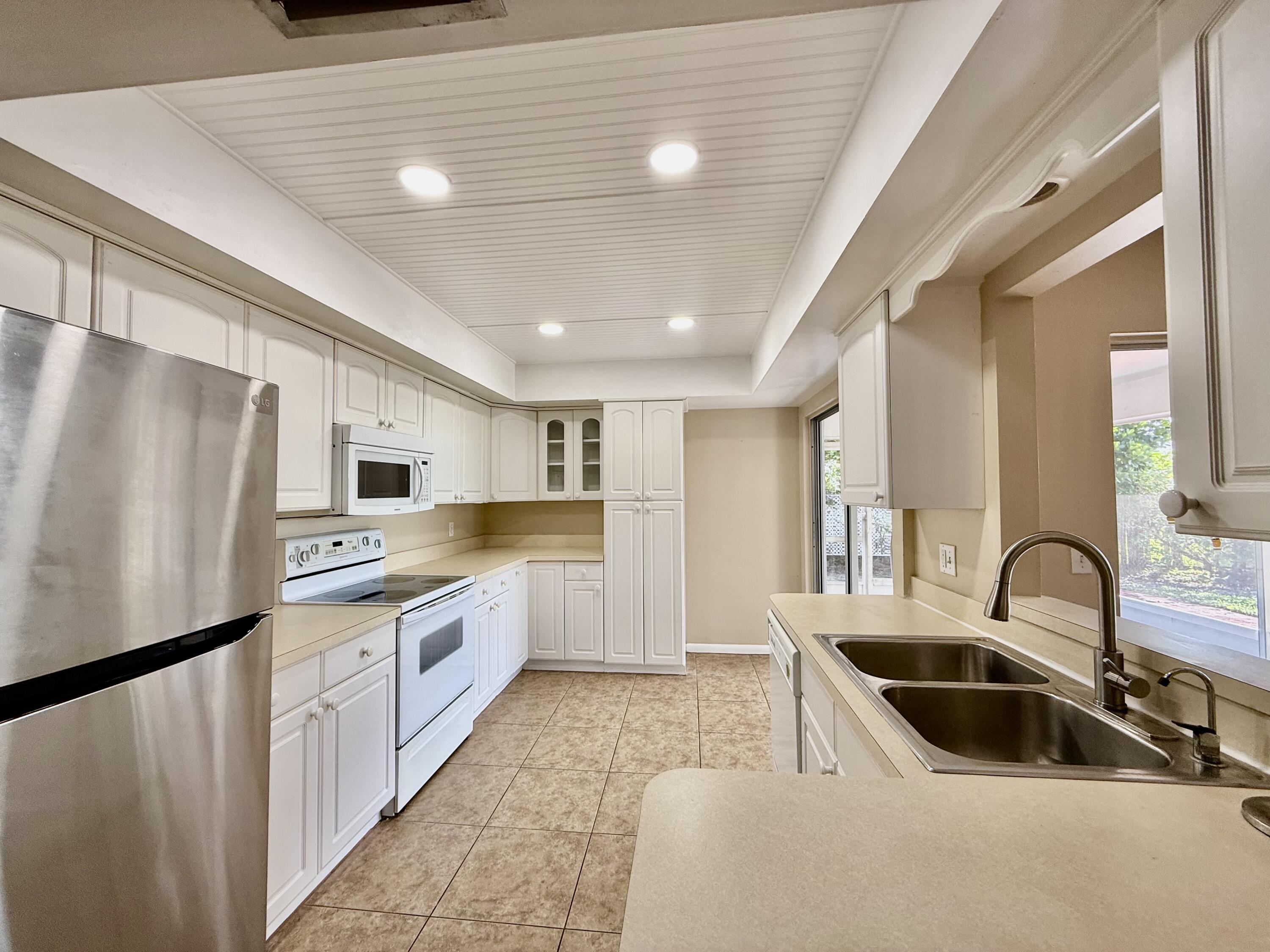 612 Coconut Avenue North Port St. Lucie, FL 34952 - Photo 23 of 32 a kitchen with stainless steel appliances granite countertop a sink and a refrigerator