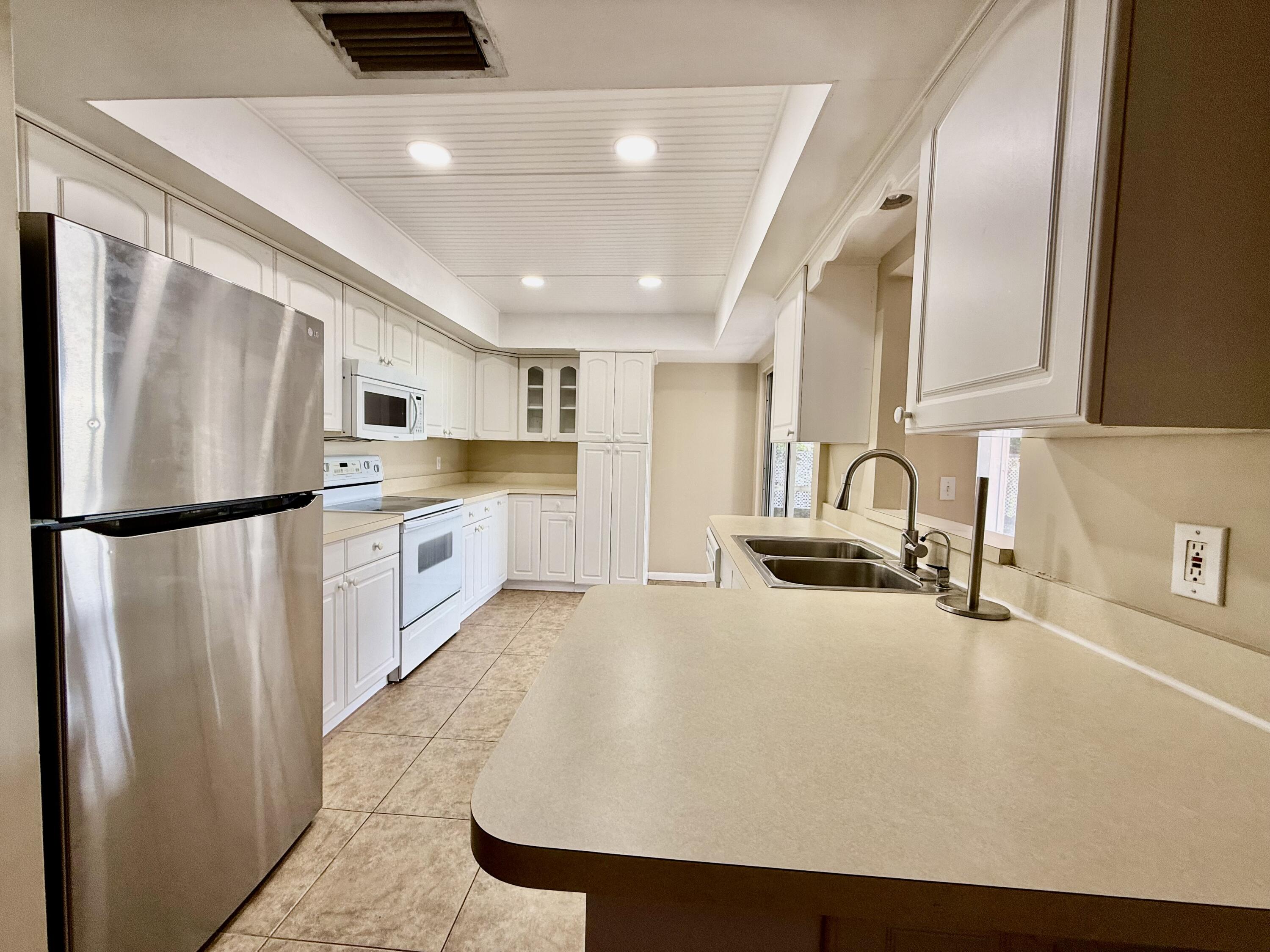 612 Coconut Avenue North Port St. Lucie, FL 34952 - Photo 24 of 32 a kitchen with stainless steel appliances a refrigerator and a sink