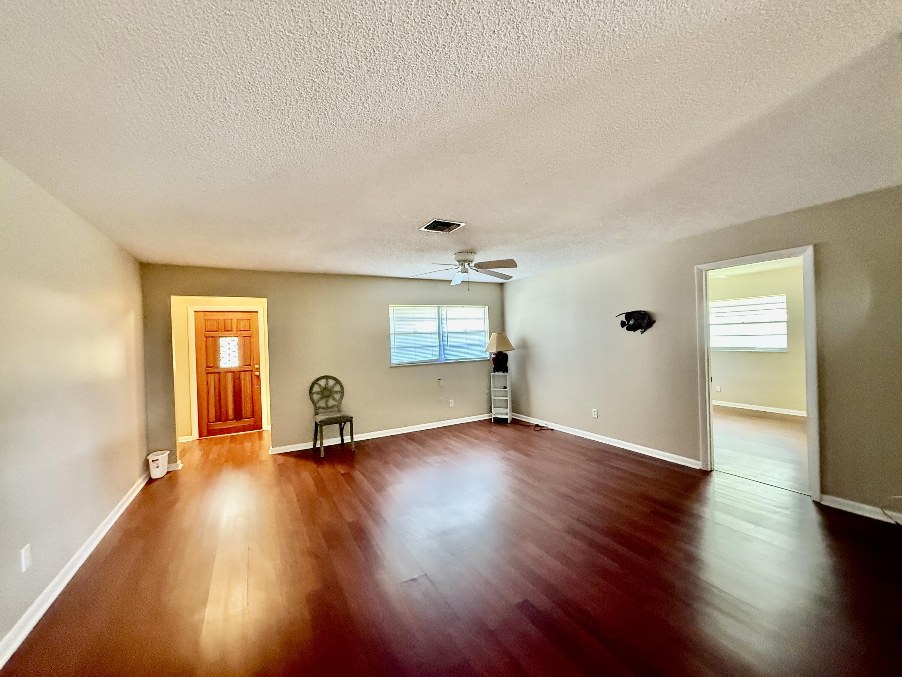 612 Coconut Avenue North Port St. Lucie, FL 34952 - Photo 25 of 32 an empty room with wooden floor and windows