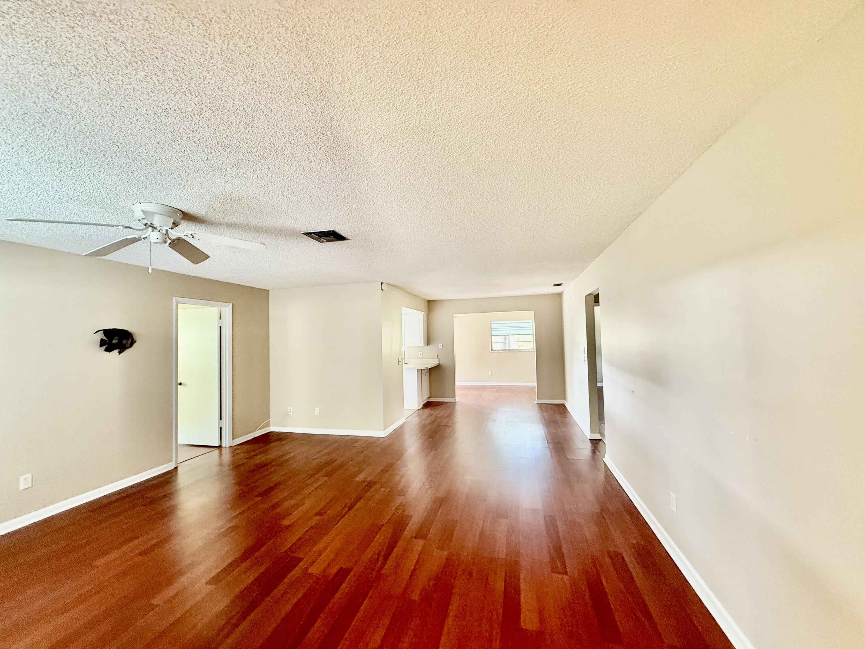 612 Coconut Avenue North Port St. Lucie, FL 34952 - Photo 28 of 32 a view of a big room with wooden floor and windows