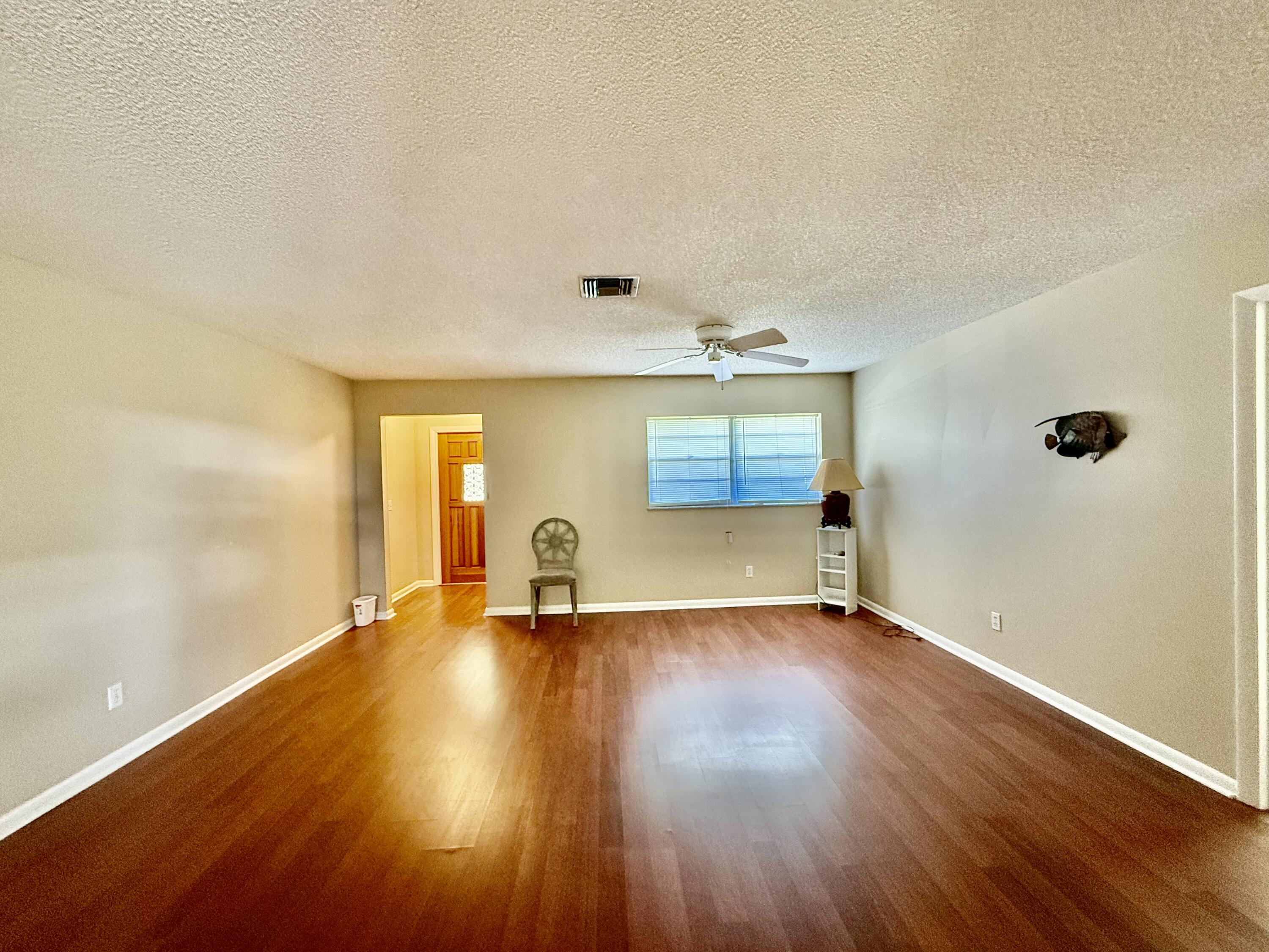 612 Coconut Avenue North Port St. Lucie, FL 34952 - Photo 3 of 32 wooden floor in an empty room with a window