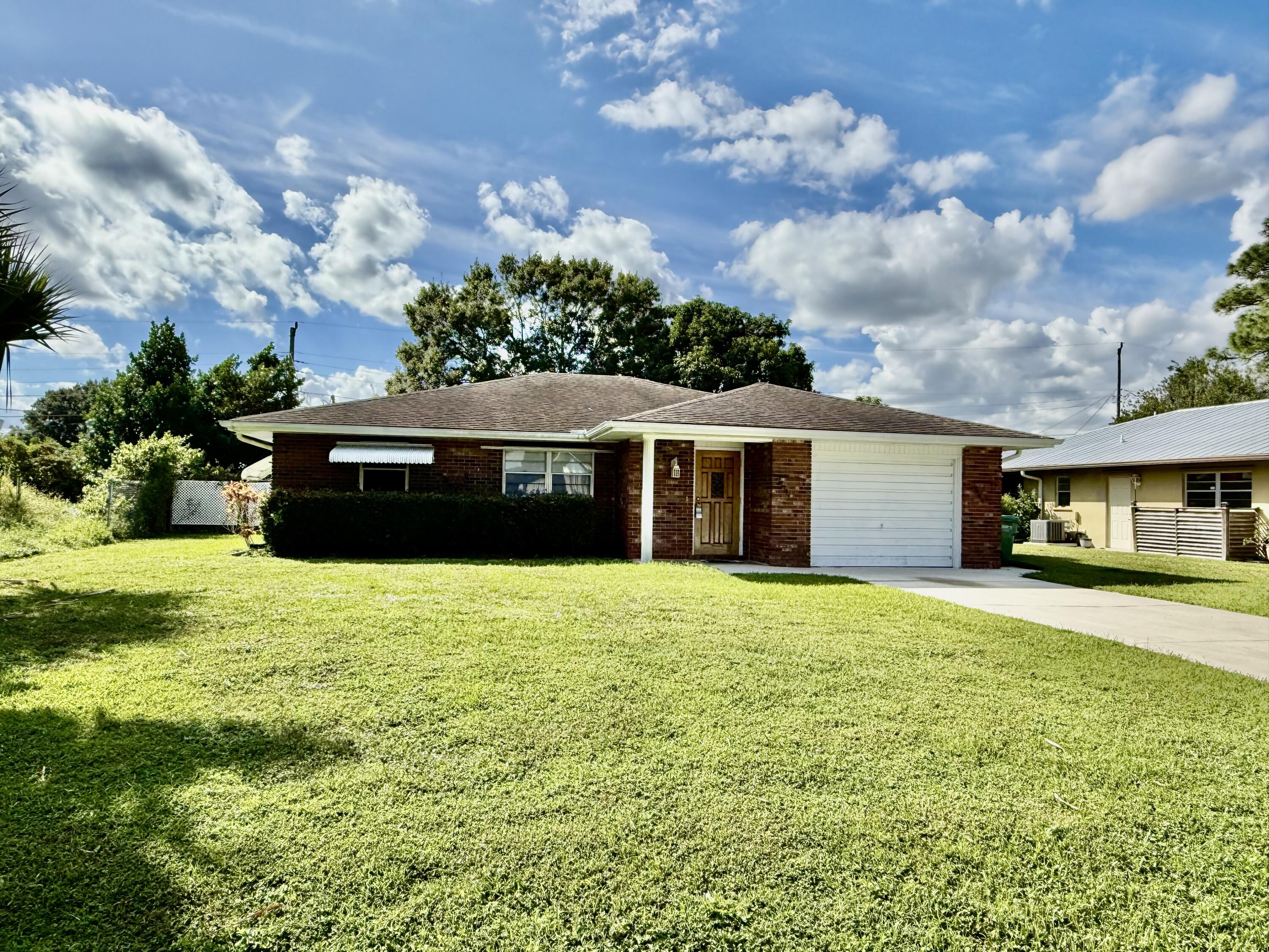 612 Coconut Avenue North Port St. Lucie, FL 34952 - Photo 31 of 32 a front view of a house with a garden
