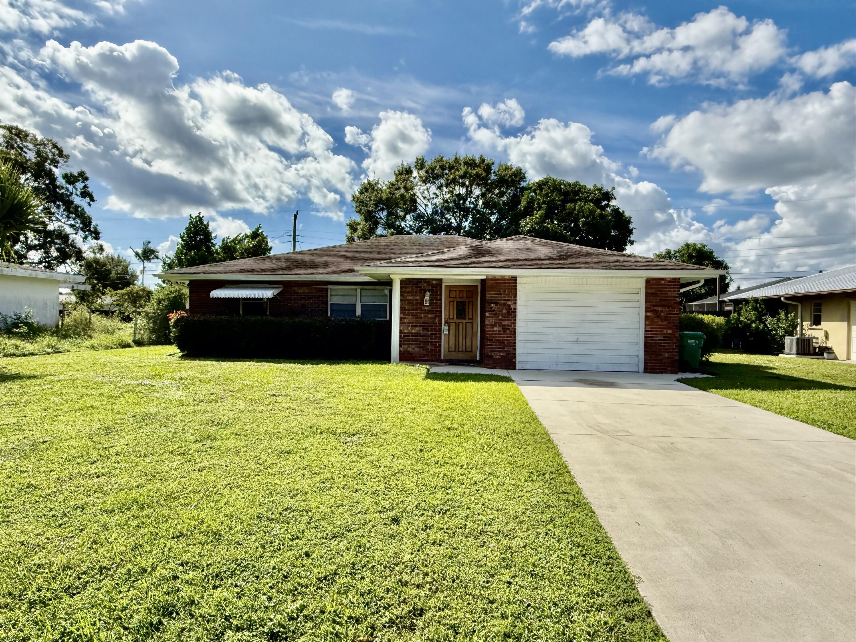 612 Coconut Avenue North Port St. Lucie, FL 34952 - Photo 32 of 32 a front view of a house with a garden