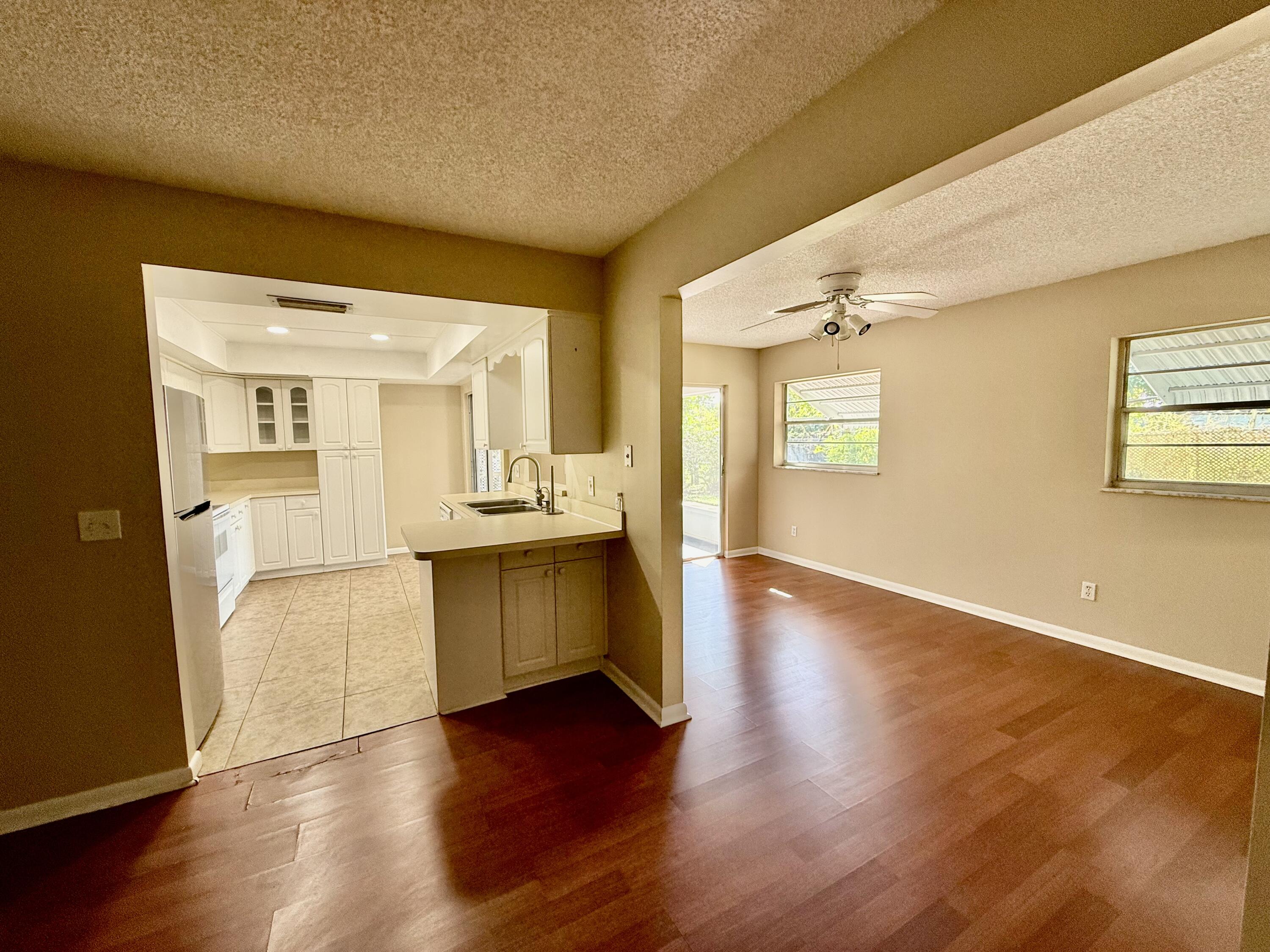 612 Coconut Avenue North Port St. Lucie, FL 34952 - Photo 4 of 32 a view of a kitchen with a refrigerator a sink and dishwasher with wooden floor