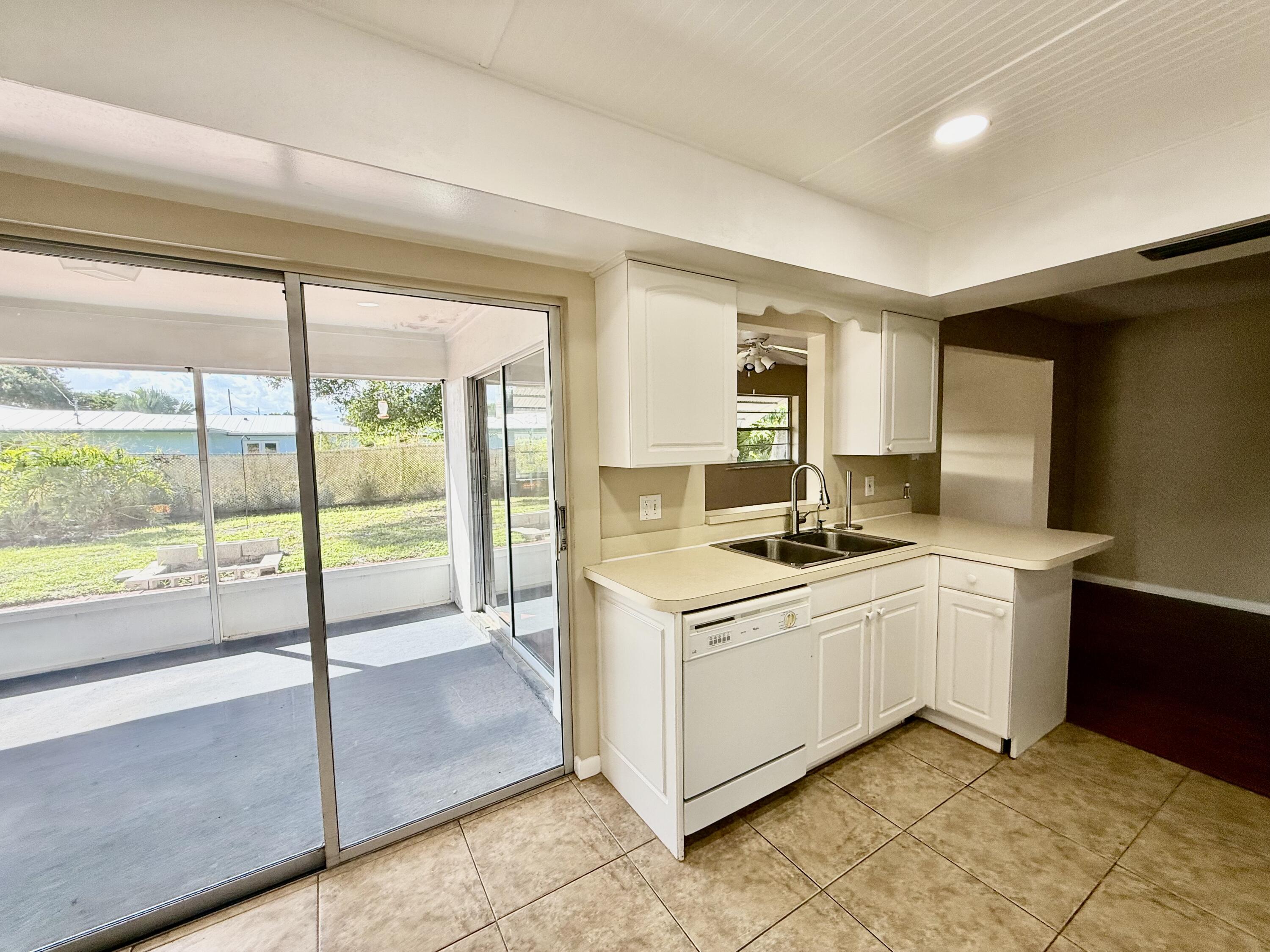 612 Coconut Avenue North Port St. Lucie, FL 34952 - Photo 5 of 32 a kitchen with a stove sink and cabinets