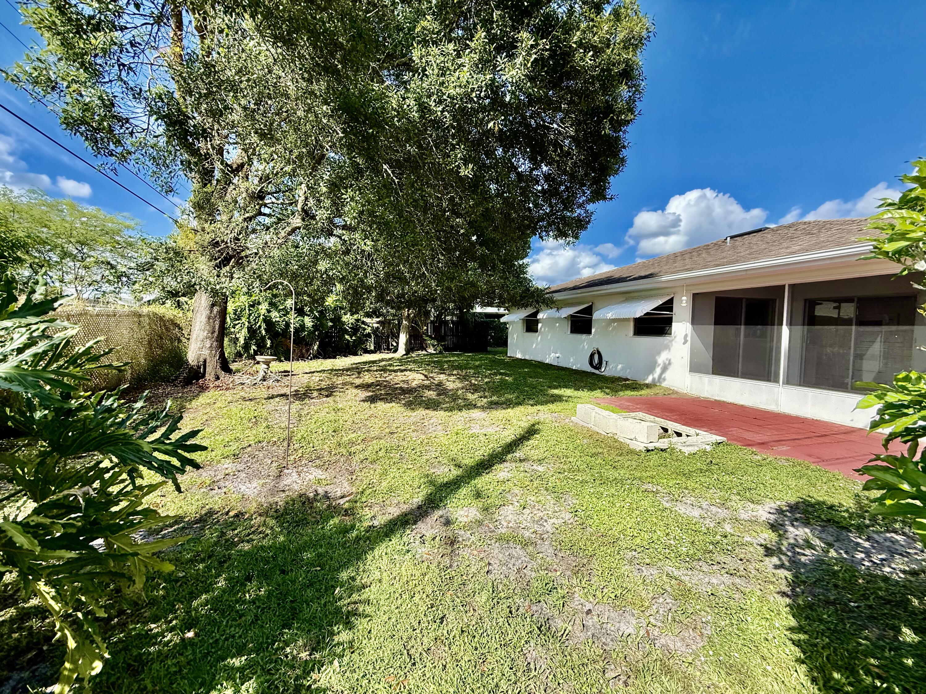 612 Coconut Avenue North Port St. Lucie, FL 34952 - Photo 9 of 32 a swimming pool with outdoor seating and yard