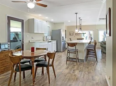 a kitchen with a dining table chairs and white cabinets