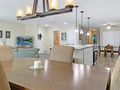 a living room with furniture kitchen view and a chandelier