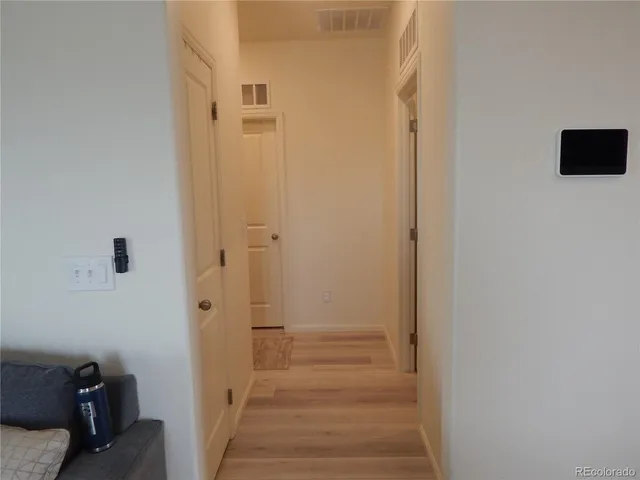 a view of a hallway with wooden floor and closet