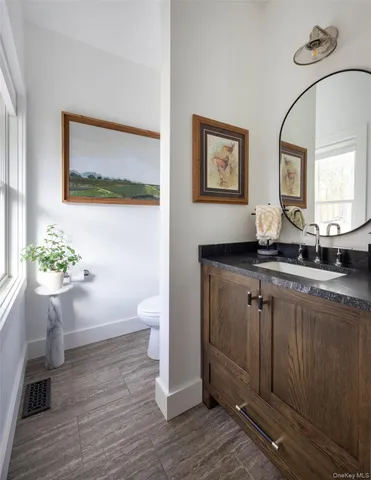 a bathroom with a granite countertop sink and a mirror