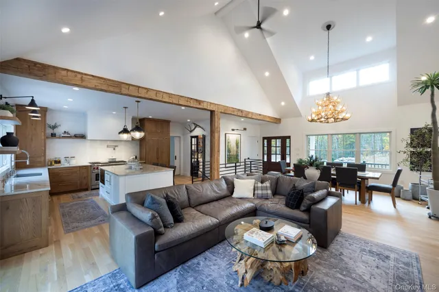 a living room with furniture kitchen view and a chandelier