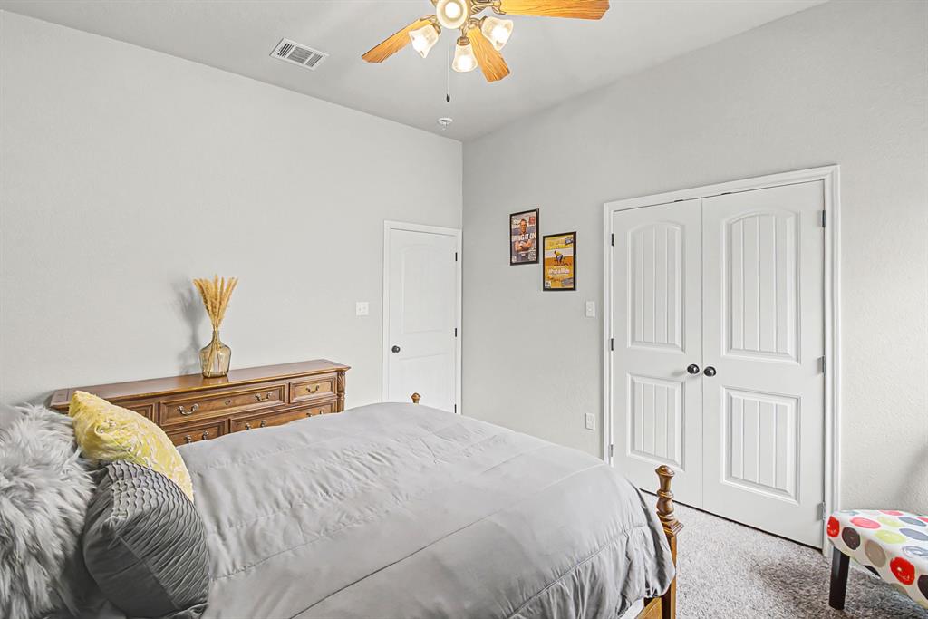 793 County Road 2535 Decatur, TX 76234 - Photo 28 of 39 a bedroom with a bed and a chandelier