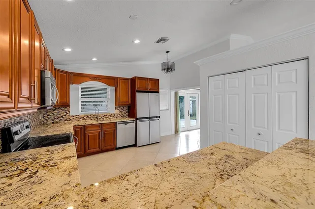 a large kitchen with stainless steel appliances granite countertop a stove sink and cabinets