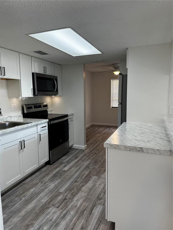 124 Loblolly Court, Unit F Oldsmar, FL 34677 - Photo 19 of 33 a kitchen with granite countertop a sink and a stove top oven