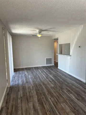 a view of empty room with wooden floor