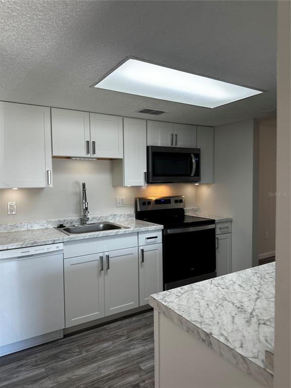 124 Loblolly Court, Unit F Oldsmar, FL 34677 - Photo 29 of 33 a kitchen with stainless steel appliances granite countertop a sink stove and refrigerator