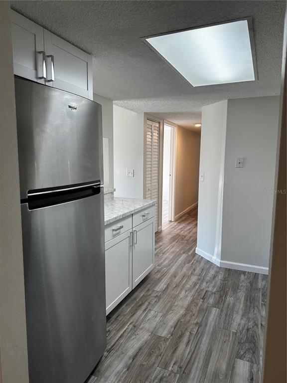 124 Loblolly Court, Unit F Oldsmar, FL 34677 - Photo 31 of 33 a kitchen with a refrigerator a sink and dishwasher with wooden floor