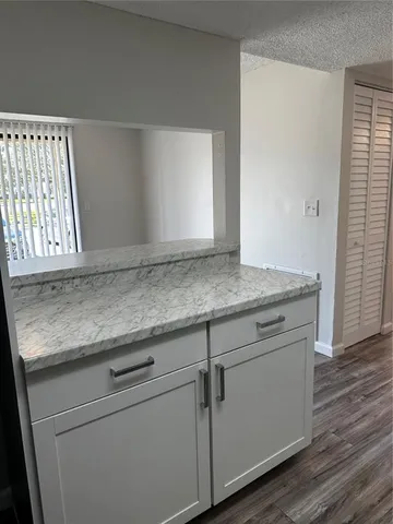 a kitchen with granite countertop a stove top oven a sink dishwasher and a refrigerator with wooden floor