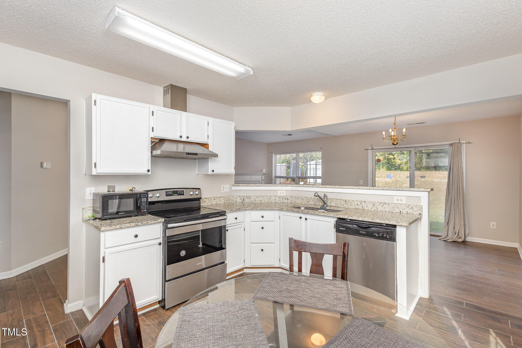 4331 Crowfield Drive Raleigh, NC 27610 - Photo 13 of 26 a kitchen with granite countertop a stove sink and cabinets