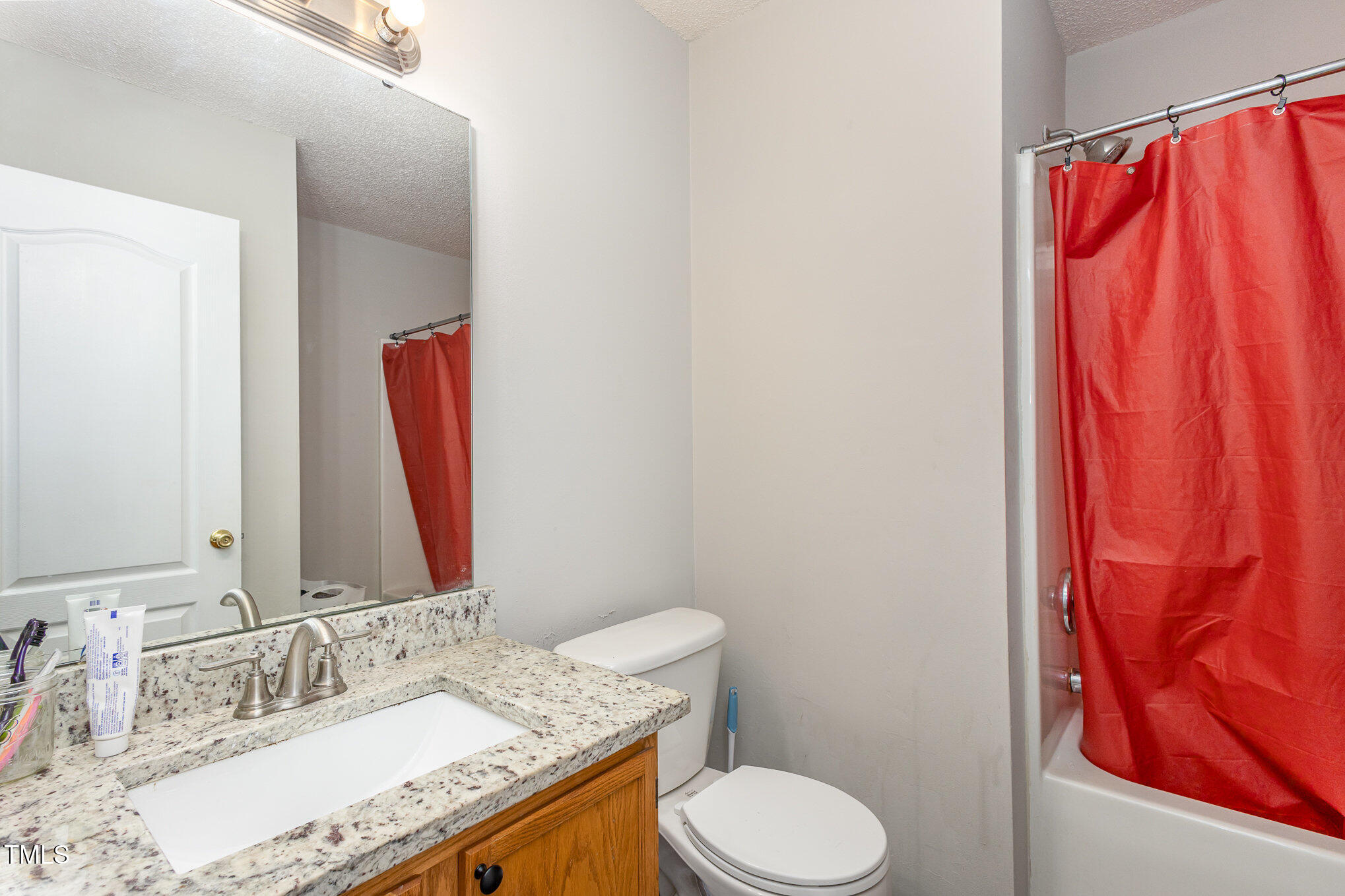 4331 Crowfield Drive Raleigh, NC 27610 - Photo 23 of 26 a bathroom with a granite countertop sink and a mirror with toilet