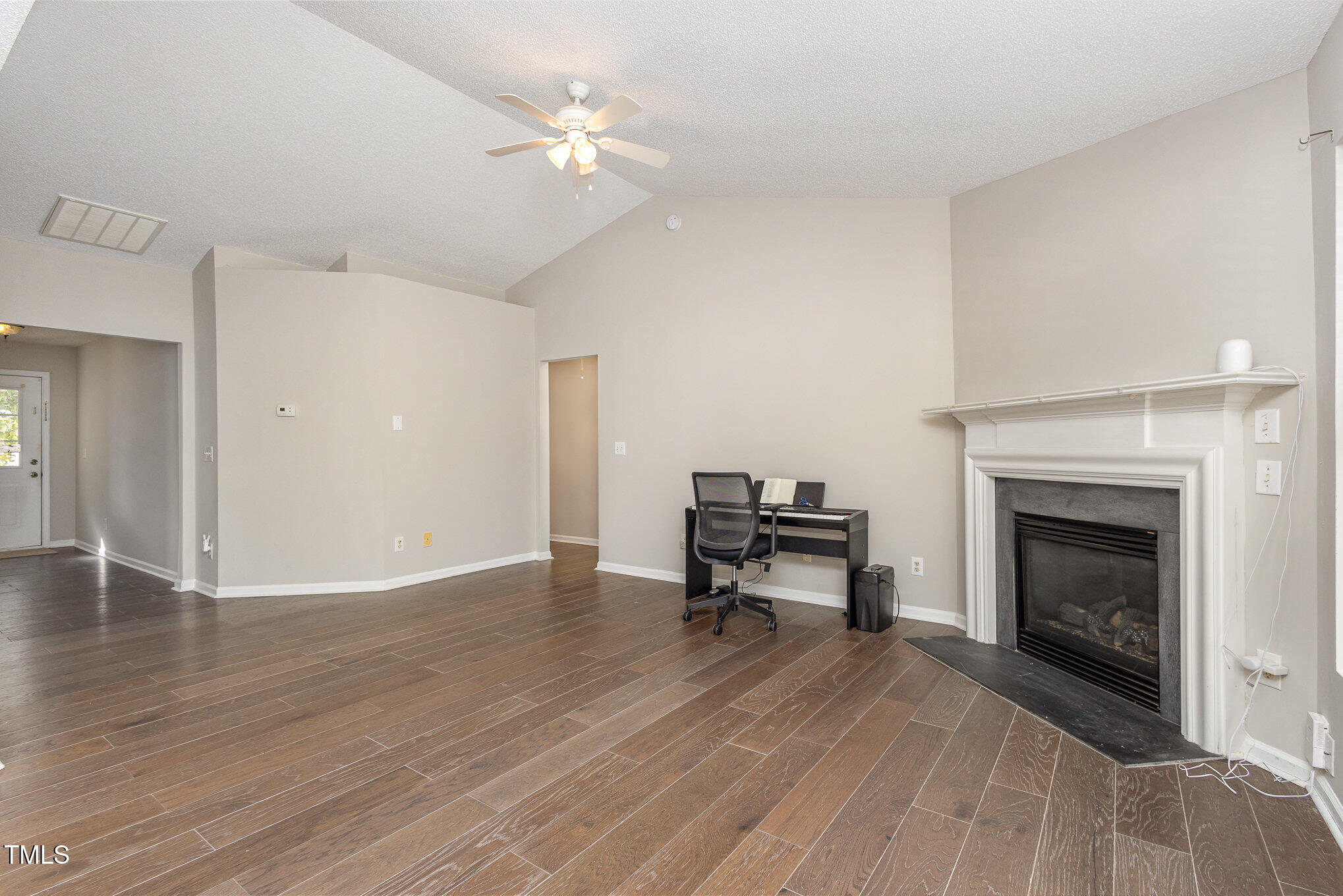 4331 Crowfield Drive Raleigh, NC 27610 - Photo 7 of 26 a view of empty room with wooden floor and fireplace