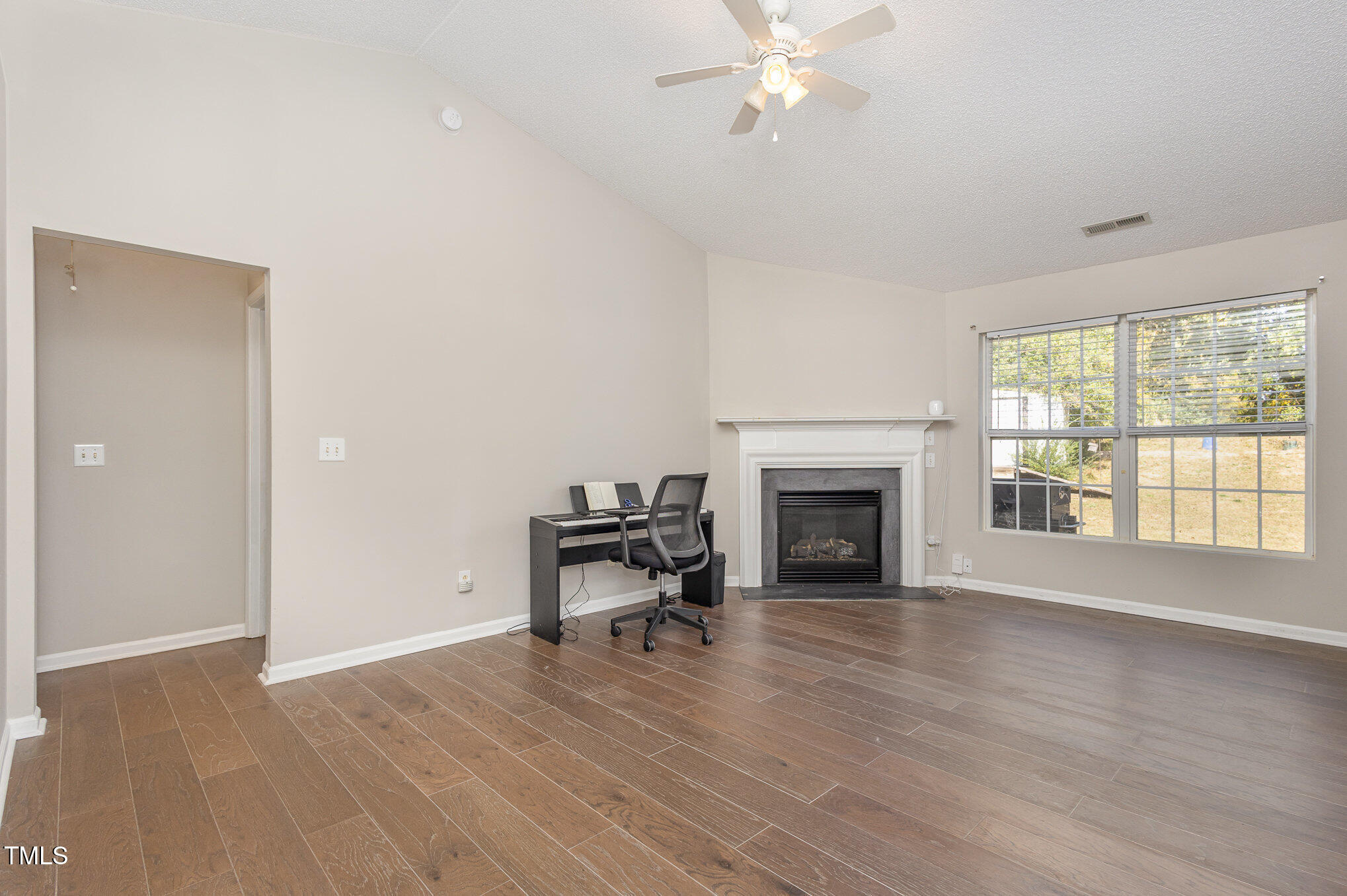 4331 Crowfield Drive Raleigh, NC 27610 - Photo 8 of 26 a view of a livingroom with a fireplace a ceiling fan and windows
