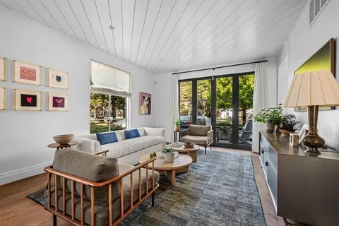 a living room with furniture a flat screen tv and a large window