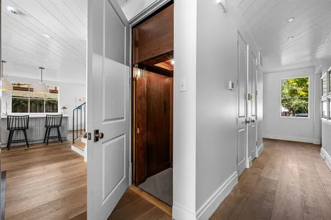 a view of hallway with stairs and wooden floor