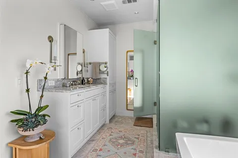 a bathroom with a granite countertop sink a toilet and a mirror