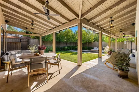 a view of a patio with a table and chairs and a barbeque