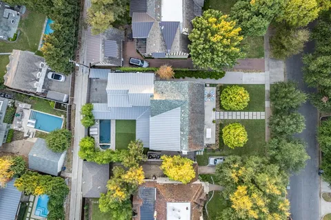 an aerial view of a house with swimming pool and garden space