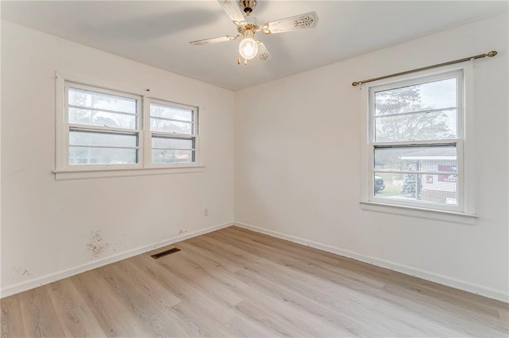 6 Don Drive Northeast Rome, GA 30165 - Photo 6 of 42 an empty room with wooden floor ceiling fan and windows