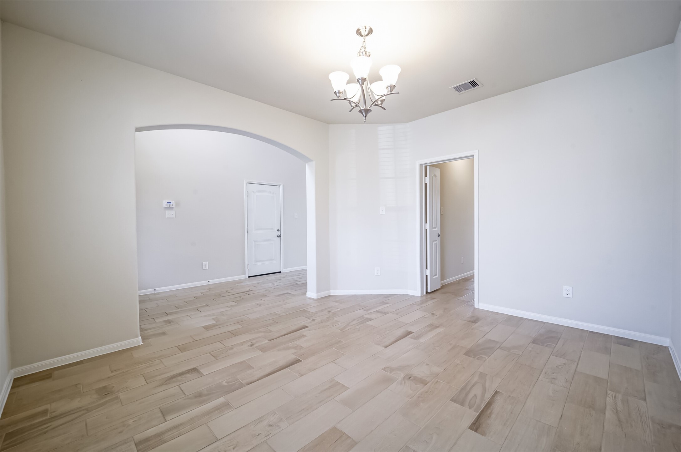 10003 Open Slope Court Humble, TX 77396 - Photo 6 of 25 Formal dining room with neutral wood look tile floors and arched opening to the foyer.