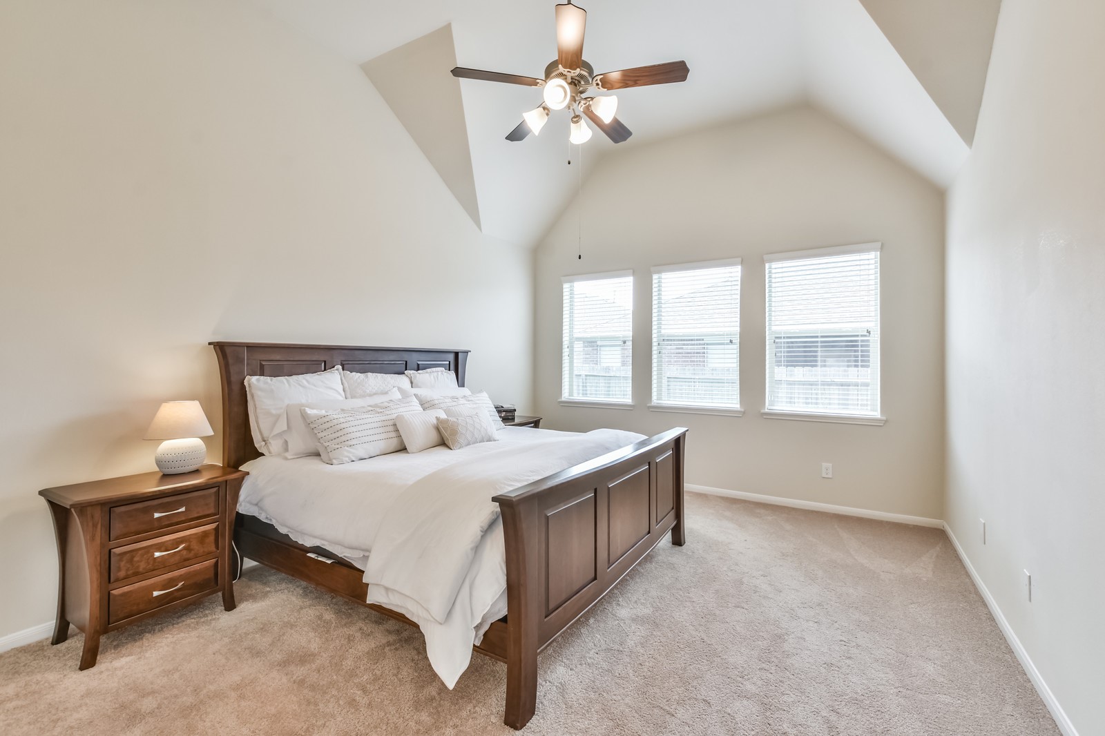 10003 Open Slope Court Humble, TX 77396 - Photo 7 of 25 The primary bedroom features vaulted ceilings, ceiling fan and neutral color palette.