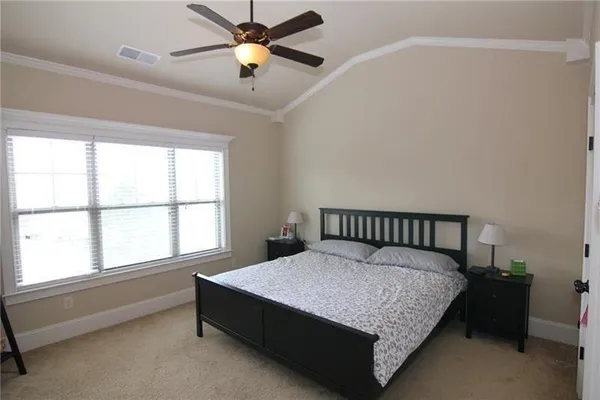 a large bedroom with a bed and a chandelier