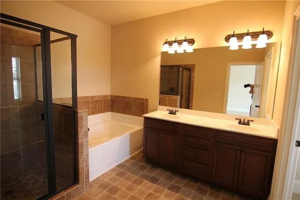 a bathroom with a tub a sink and a mirror