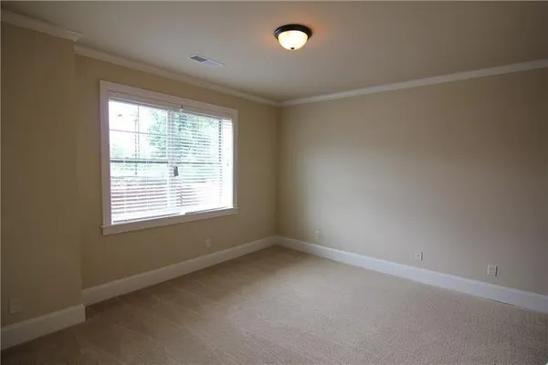 a view of an empty room with closet and a window