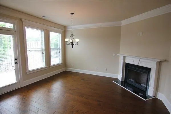 an empty room with fireplace and windows