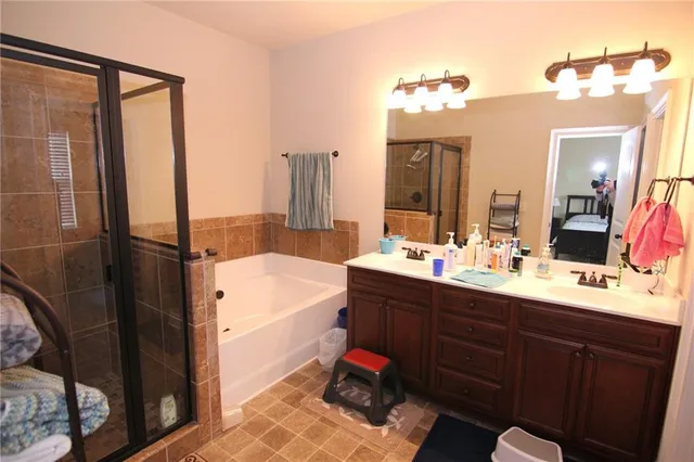 a bathroom with a tub sink vanity and toilet