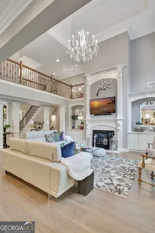 a kitchen with stainless steel appliances kitchen island granite countertop a stove top oven a sink a refrigerator with white cabinets and wooden floor