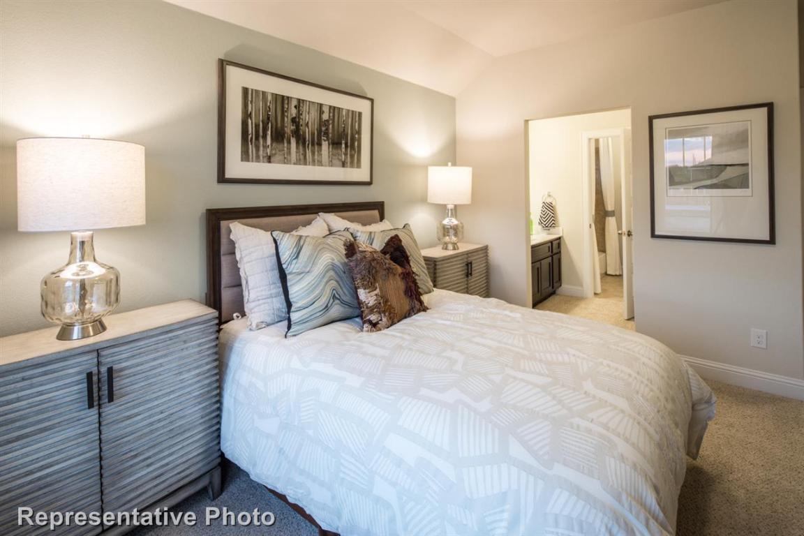 164 Linnet Lane Maxwell, TX 78656 - Photo 29 of 40 a bedroom with a bed and a lamp on dresser