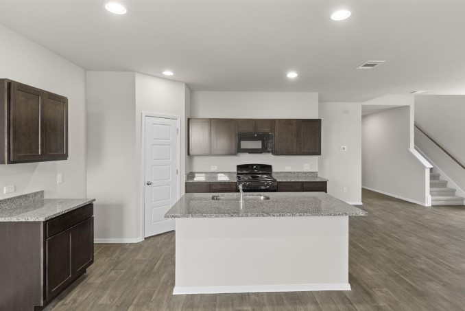 164 Linnet Lane Maxwell, TX 78656 - Photo 3 of 40 a large kitchen with stainless steel appliances granite countertop a stove a sink and a refrigerator